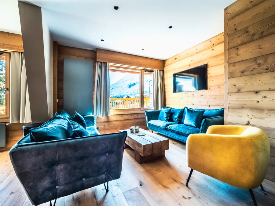 Salon avec canapé bleu et fauteuil jaune