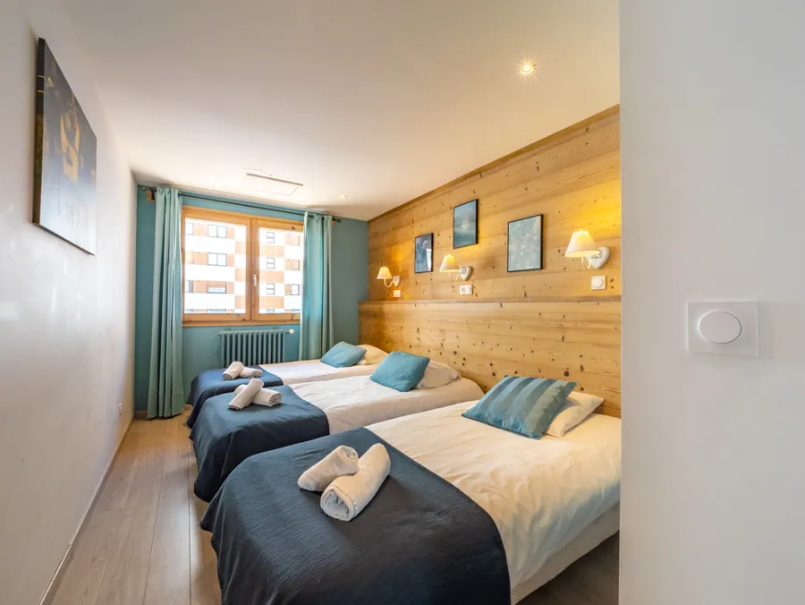 Chambre à deux lits et mur habillé de bois