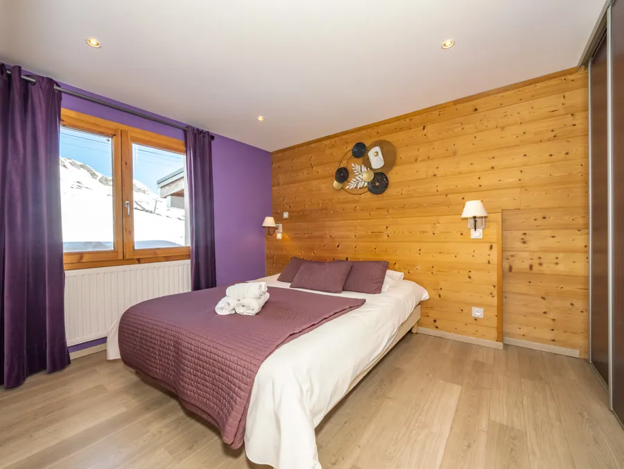 Chambre aux tons violets et aux matières bois