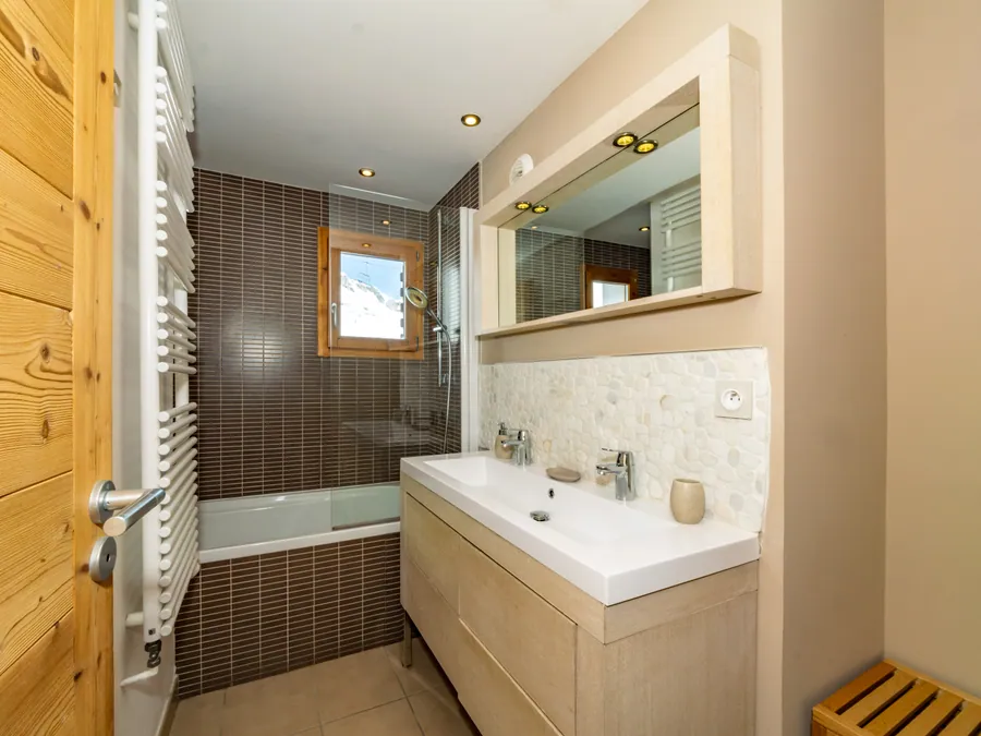 Salle de bain avec baignoire et meuble vasque