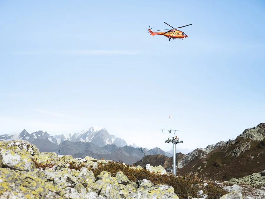 Héliportage d’un élément de pylône sur le chantier du Transarc