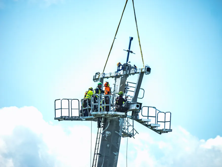Pose de la tête de pylône par hélicoptère sur le chantier du Transarc