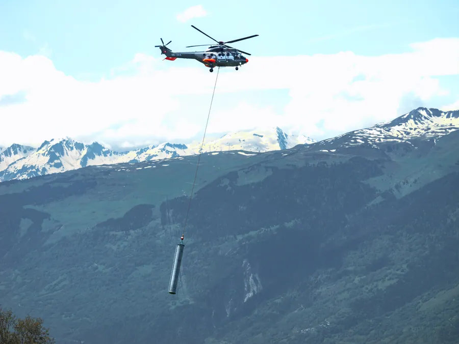 Héliportage au-dessus du paysage alpin sur le chantier du Transarc