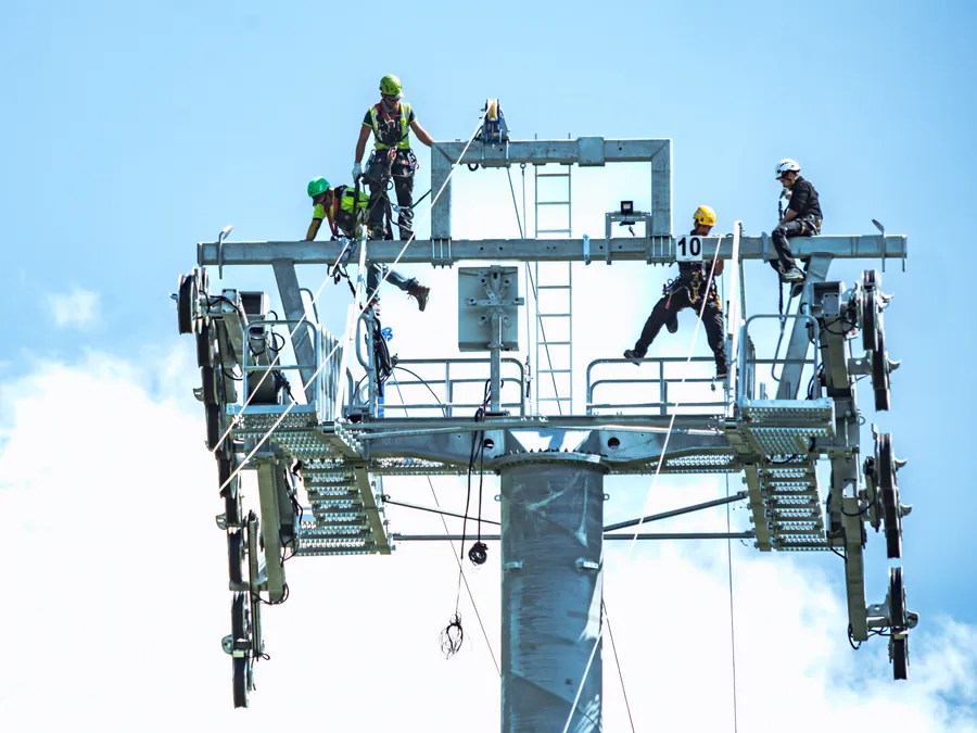 Équipe au travail sur une tête de pylône sur le chantier du Transarc