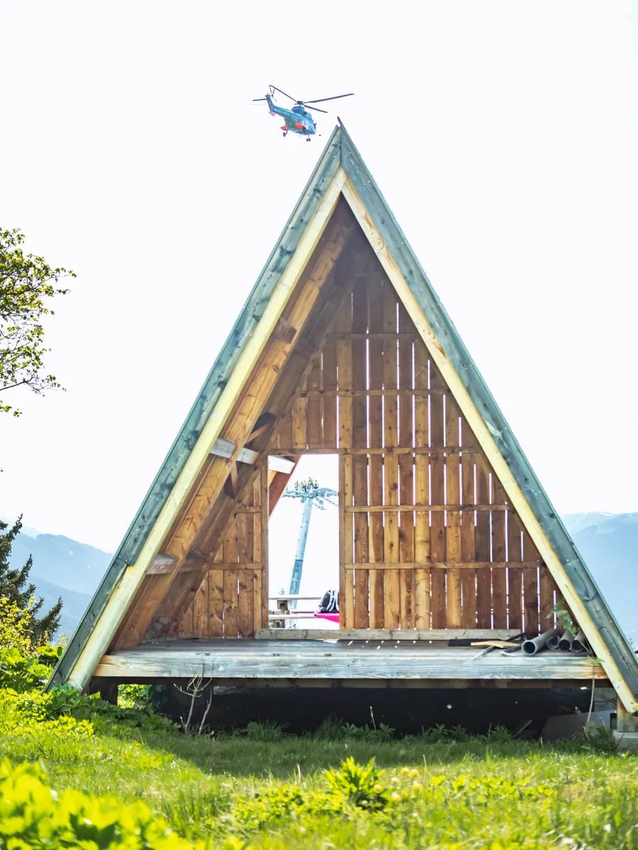 Hélicoptère au-dessus d’un bâtiment en montagne sur le chantier du Transarc