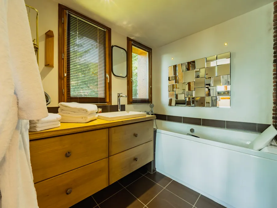 Le meuble en bois et la baignoire de la salle de bain